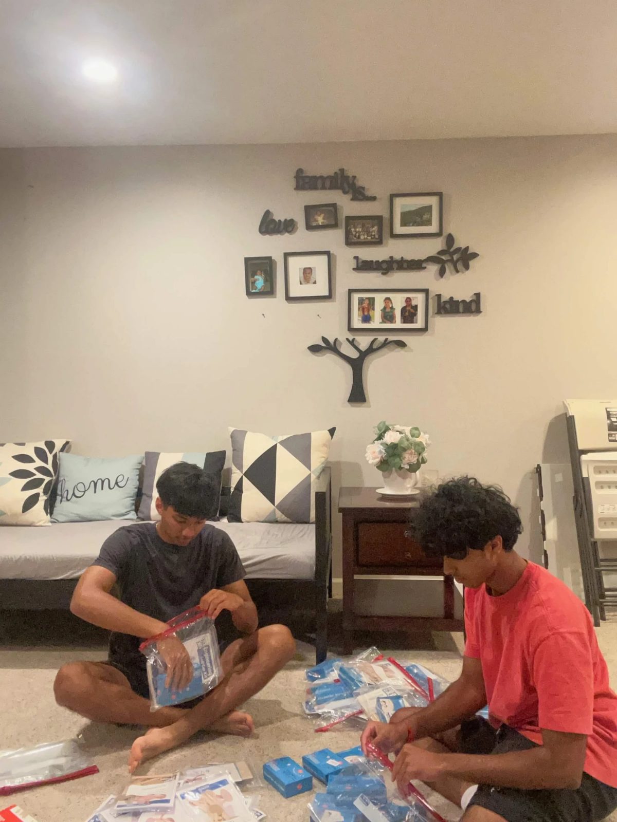 Two Future Spark students packing kits on a living room floor